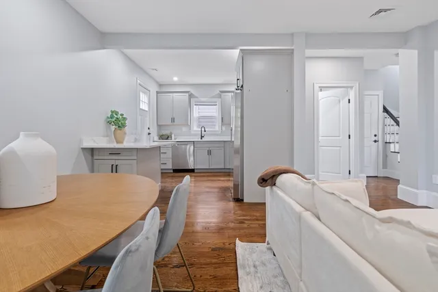 a living room with stainless steel appliances furniture a couch and a dining table