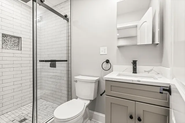 a bathroom with a sink a toilet and shower