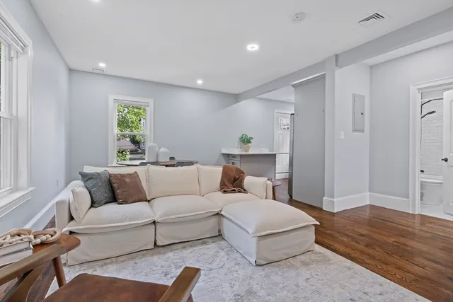 a living room with furniture and a wooden floor
