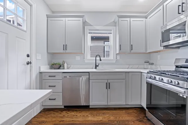 a kitchen with white cabinets and white appliances