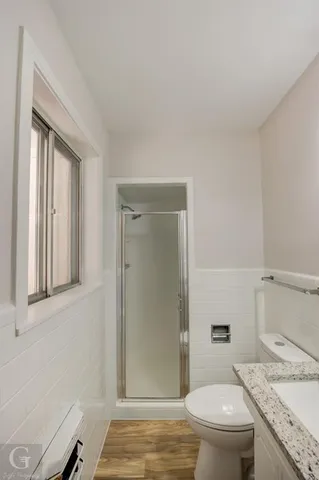 a bathroom with a granite countertop toilet a sink and a mirror