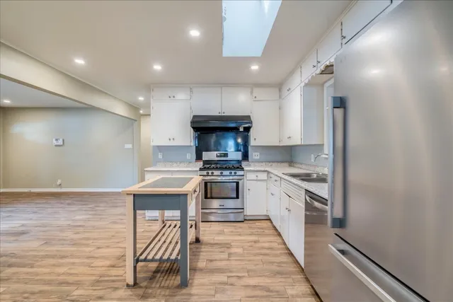 a kitchen with granite countertop a stove and a refrigerator