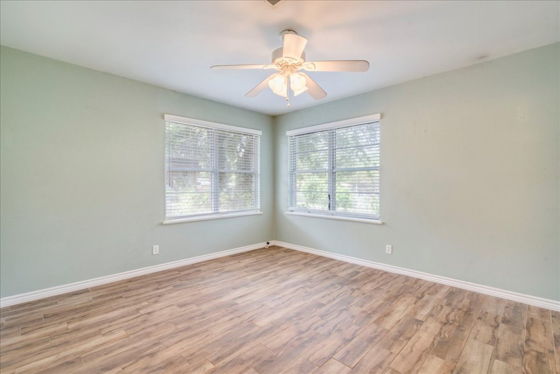 4712 Frontier Trail Austin, TX 78745 - Photo 16 of 32 a view of an empty room with wooden floor and a window