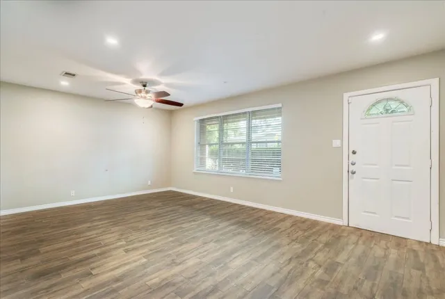 wooden floor in an empty room with a window