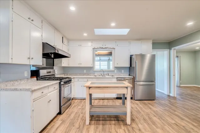 a kitchen with a stove a refrigerator and a sink