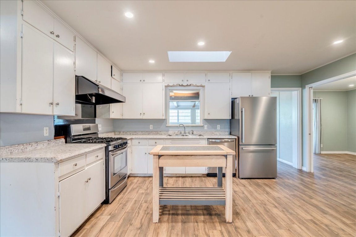 4712 Frontier Trail Austin, TX 78745 - Photo 9 of 32 a kitchen with a stove a refrigerator and a sink