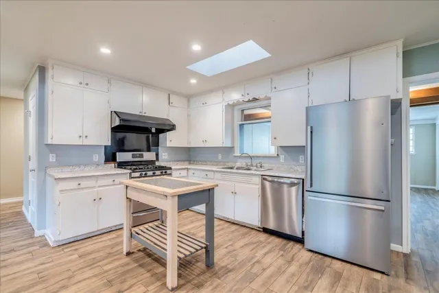 a kitchen with stainless steel appliances a refrigerator stove microwave and cabinets