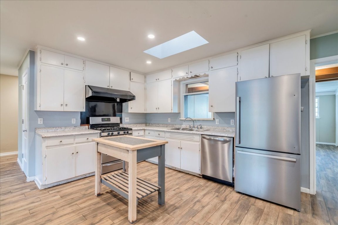 4712 Frontier Trail Austin, TX 78745 - Photo 10 of 32 a kitchen with stainless steel appliances a refrigerator stove microwave and cabinets