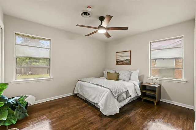 a bedroom with a bed wooden floor and window