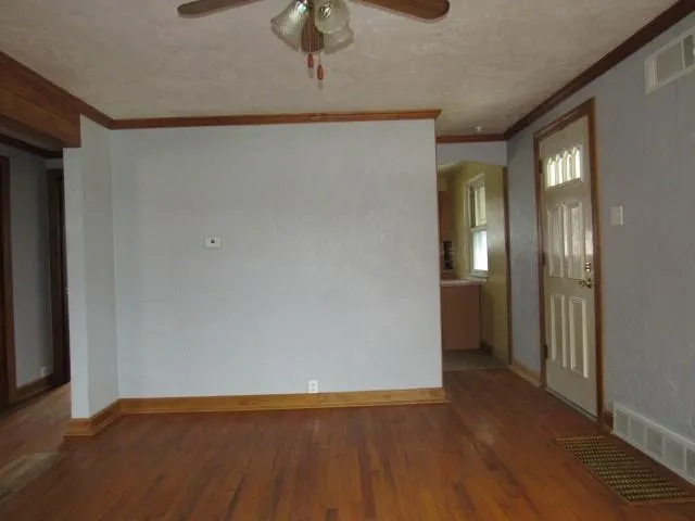 a view of a big room with wooden floor and windows