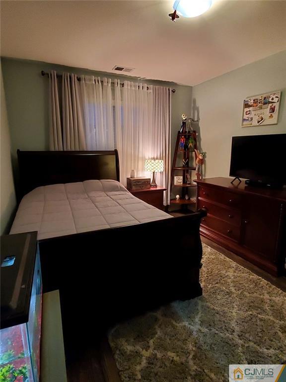 4 Raritan Reach Road, Unit 1002 South Amboy, NJ 08879 - Photo 11 of 19 a bed sitting in a bedroom next to a window