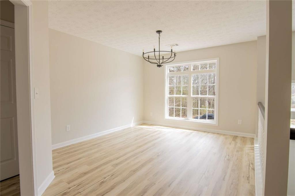 824 Eastmont Road Winder, GA 30680 - Photo 12 of 35 a view of an empty room with wooden floor fridge and a window