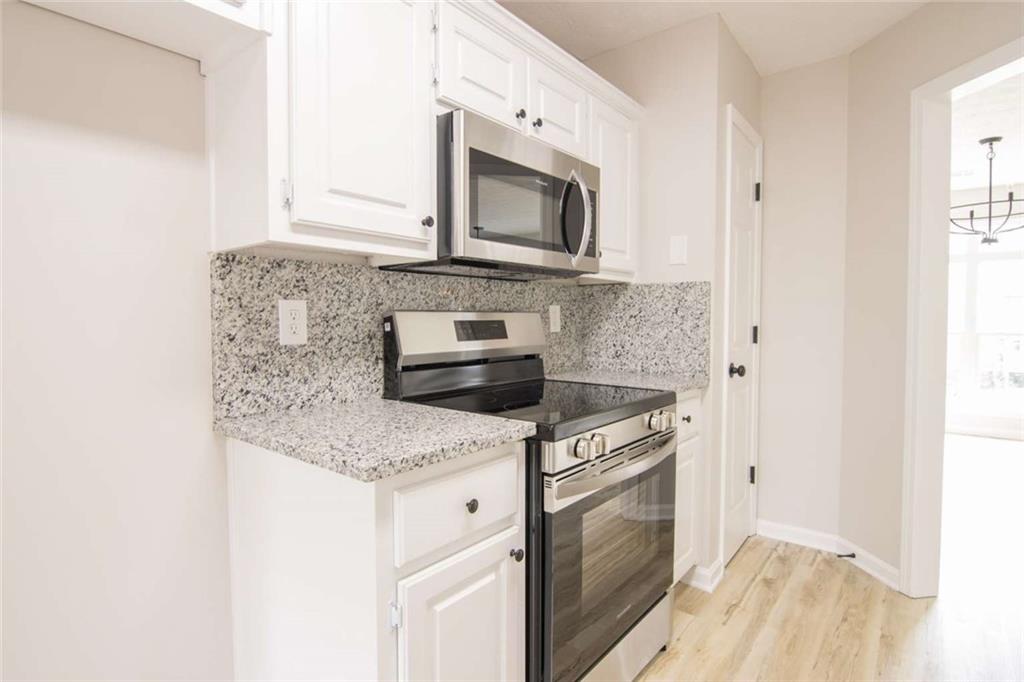 824 Eastmont Road Winder, GA 30680 - Photo 18 of 35 a kitchen with granite countertop a stove and a microwave
