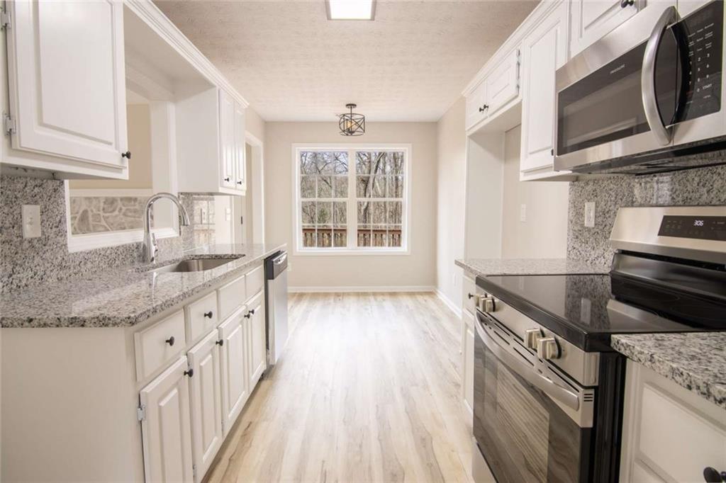 824 Eastmont Road Winder, GA 30680 - Photo 20 of 35 a kitchen with stainless steel appliances granite countertop a sink and a stove