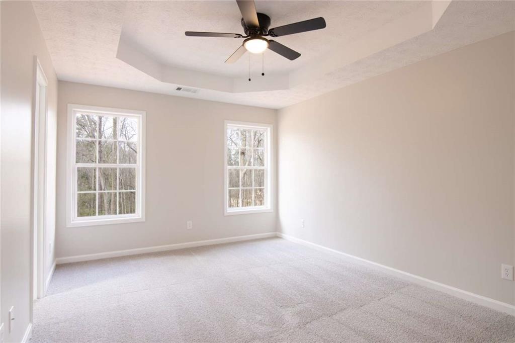 824 Eastmont Road Winder, GA 30680 - Photo 24 of 35 an empty room with chandelier fan and windows