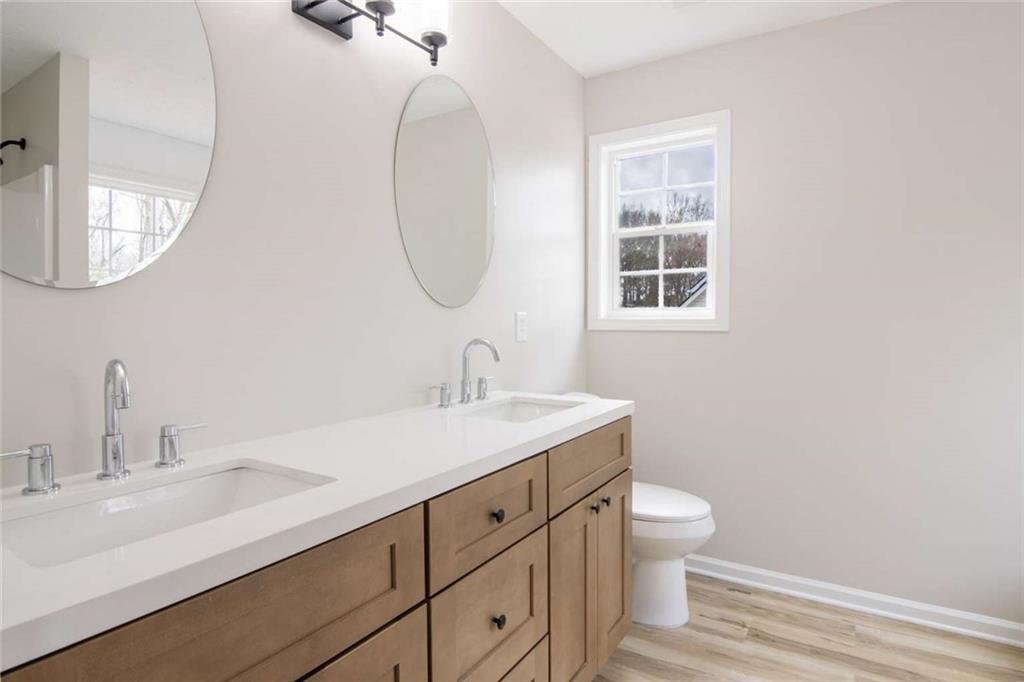 824 Eastmont Road Winder, GA 30680 - Photo 6 of 35 a bathroom with a toilet a sink a mirror and a window
