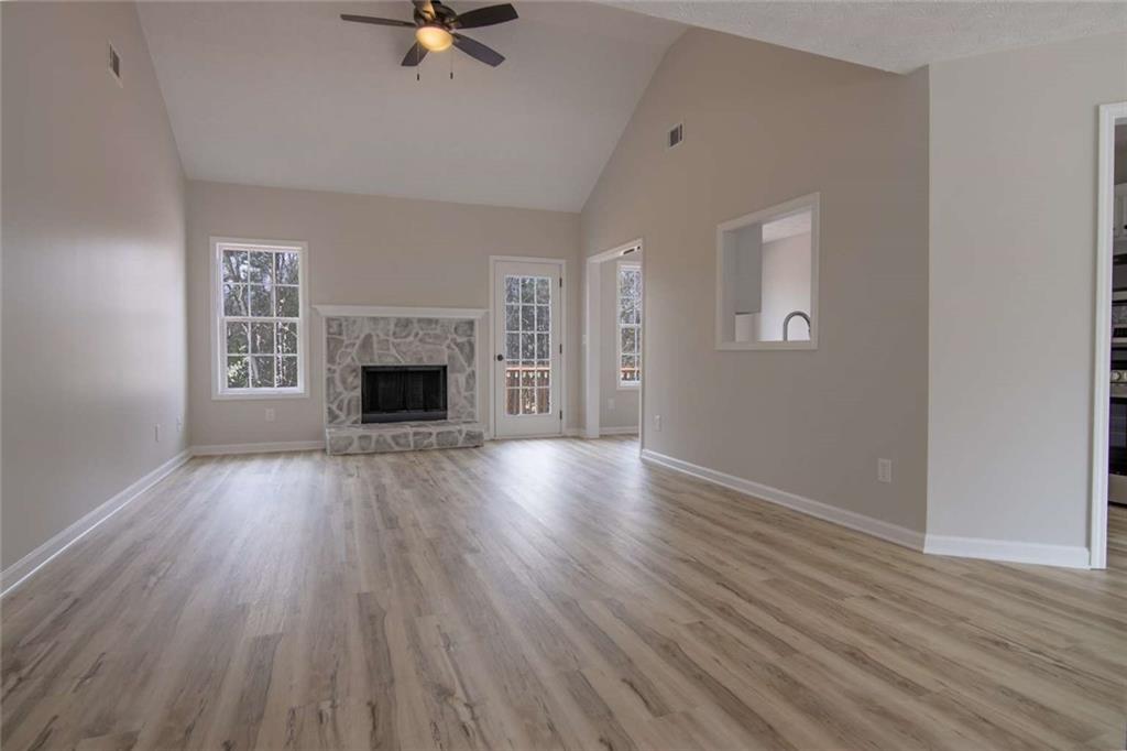 824 Eastmont Road Winder, GA 30680 - Photo 10 of 35 an empty room with wooden floor fireplace and windows
