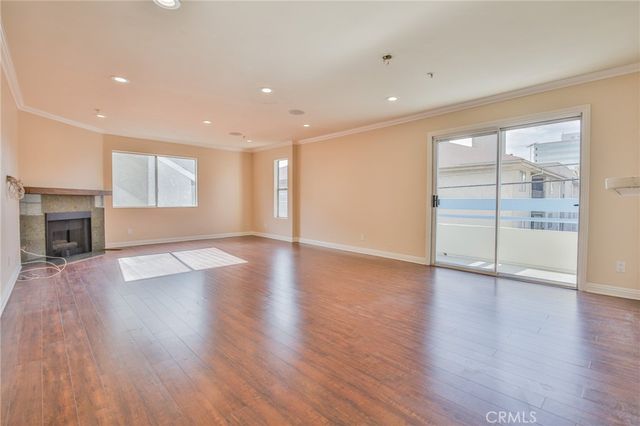 a view of empty room with wooden floor and fireplace