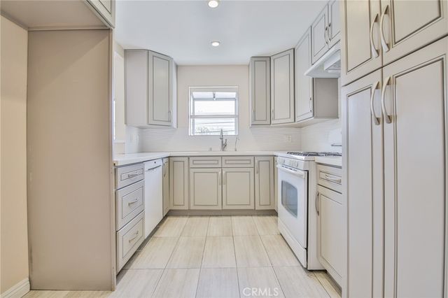 a kitchen with white cabinets stainless steel appliances and sink