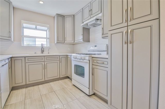 a view of an empty room with wooden floor and a fireplace