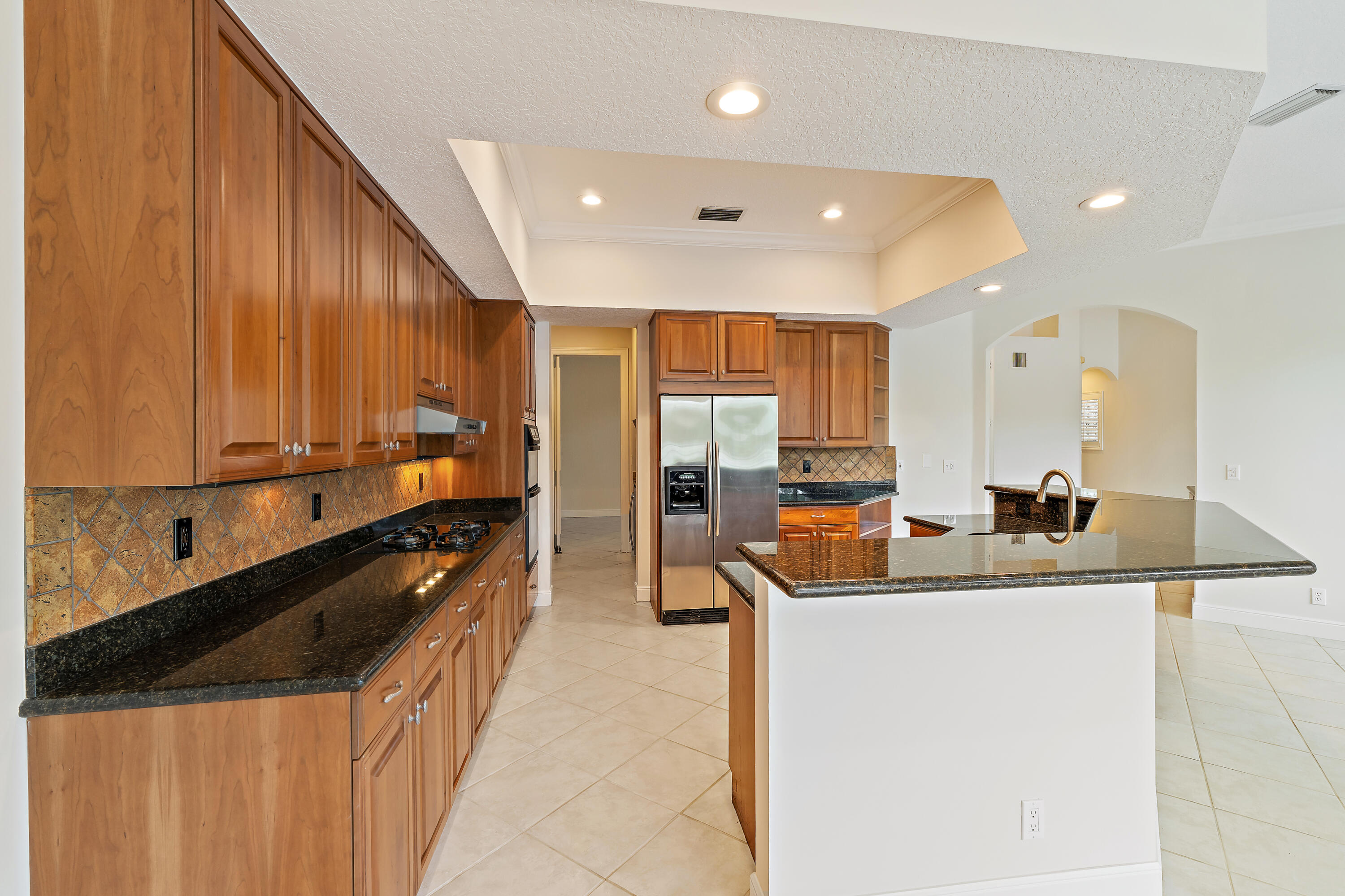 111 Fishermans Way Jupiter, FL 33477 - Photo 17 of 57 a kitchen with kitchen island granite countertop a sink a counter top space appliances and cabinets