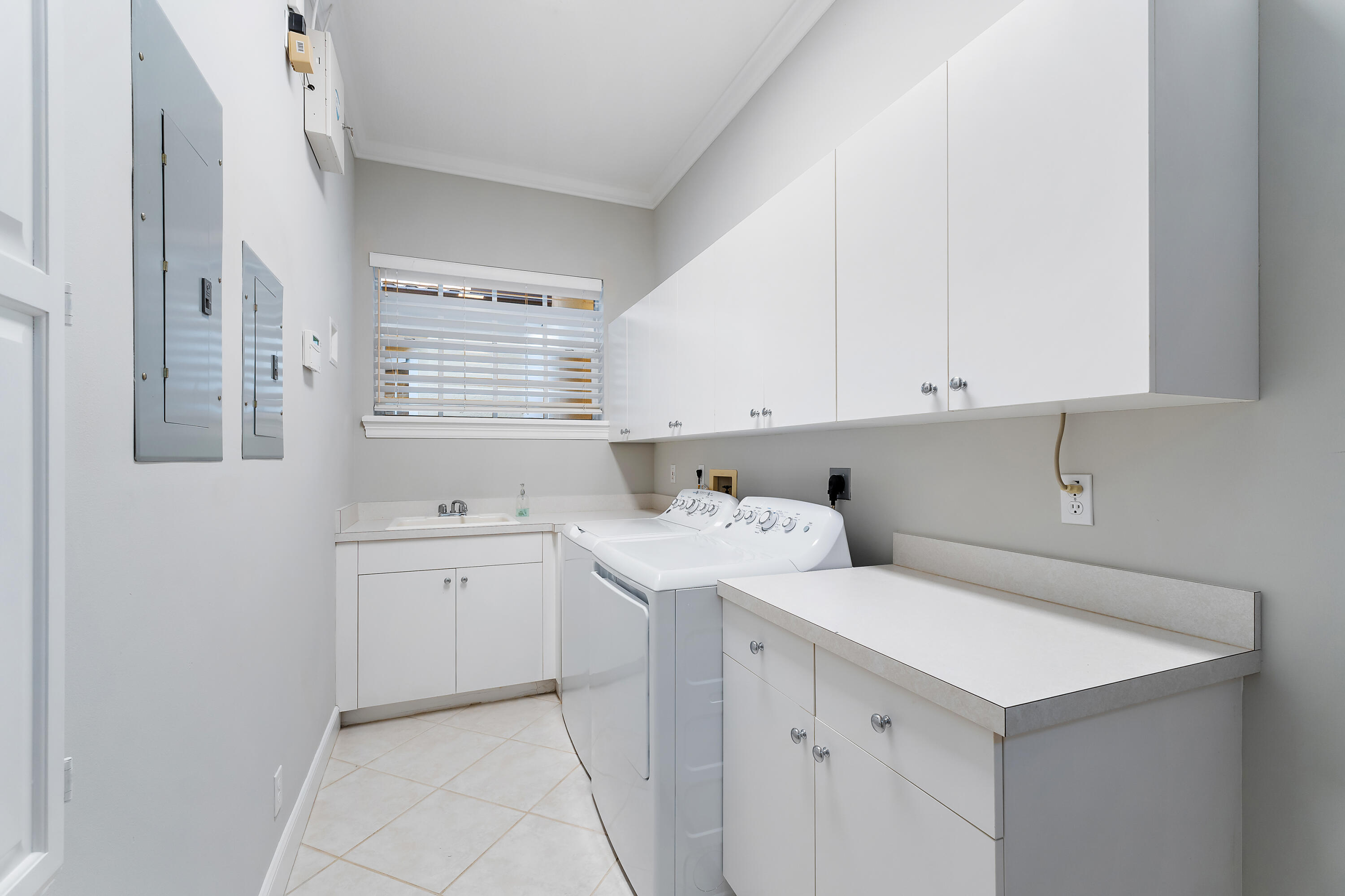 111 Fishermans Way Jupiter, FL 33477 - Photo 45 of 57 a utility room with cabinets washer and dryer