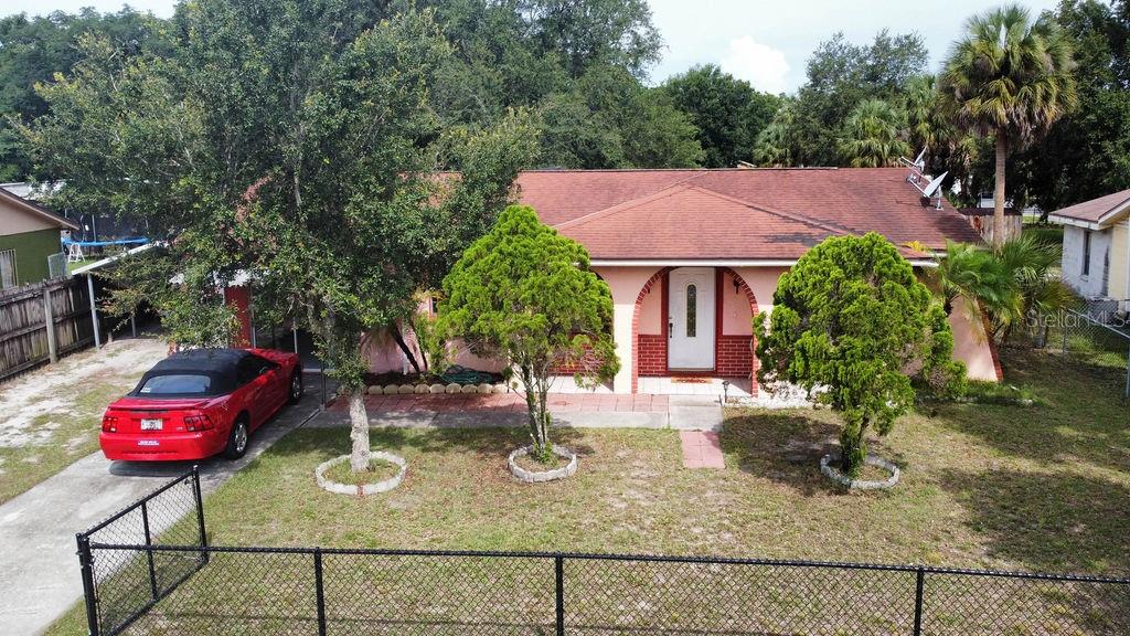 1814 Green Ridge Road Tampa, FL 33619 - Photo 1 of 1 a view of a backyard with table and chairs potted plants and large tree