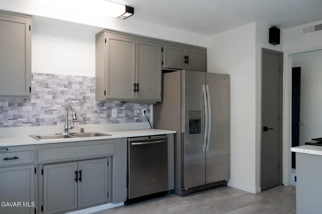 a kitchen with stainless steel appliances a refrigerator sink and cabinets