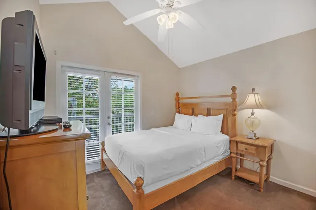 a bedroom with a bed and a flat tv screen on dresser