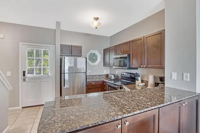 a kitchen with stainless steel appliances granite countertop a sink refrigerator and microwave