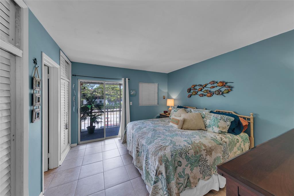 11 Southwest 4th Avenue, Unit 11 Boca Raton, FL 33432 - Photo 19 of 39 a bedroom with a large bed and a potted plant