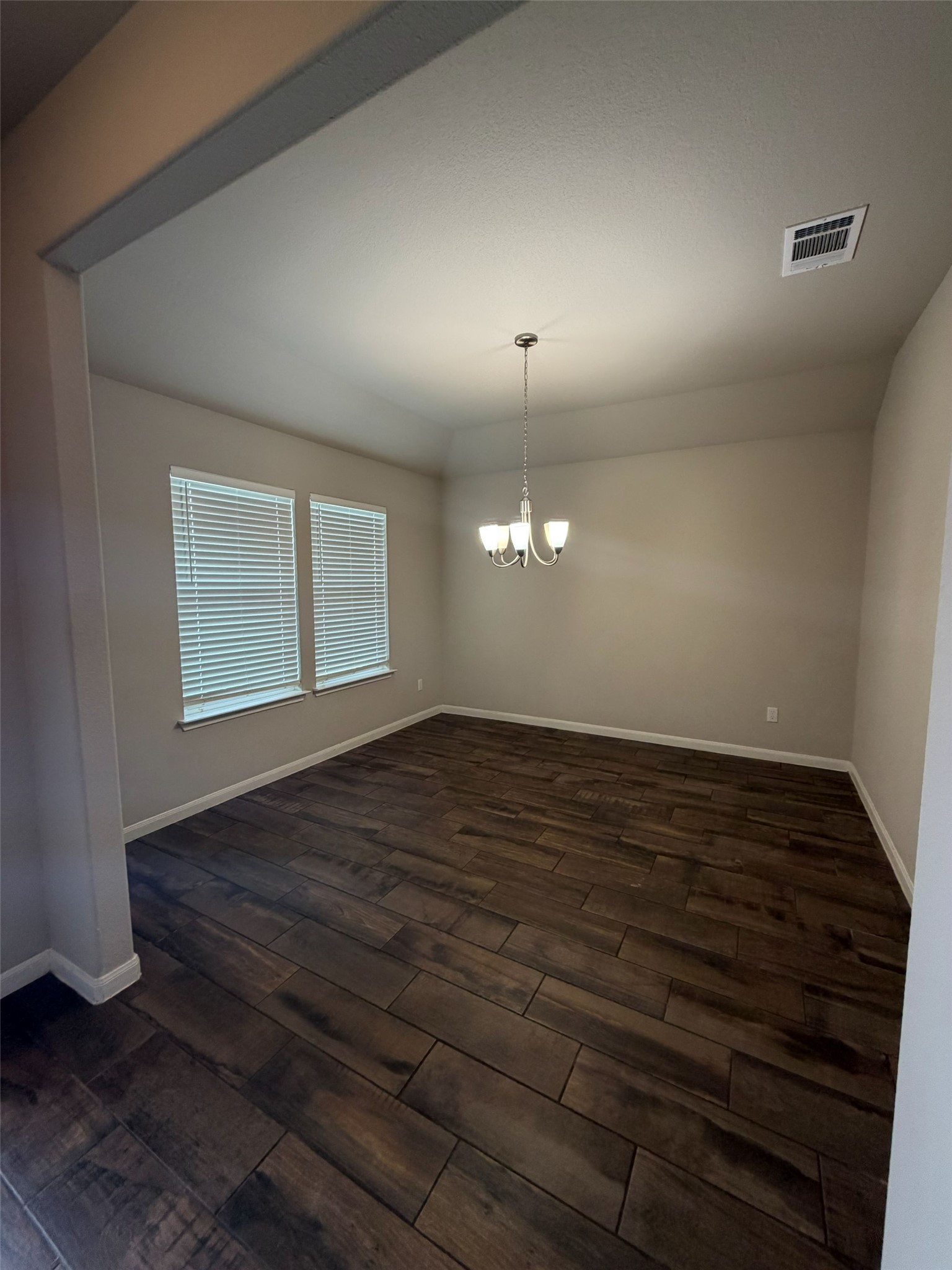 248 Falling Star Lane Georgetown, TX 78628 - Photo 4 of 16 Rich hardwood-style flooring extends across this spacious dining area, illuminated by natural light and a classic chandelier.