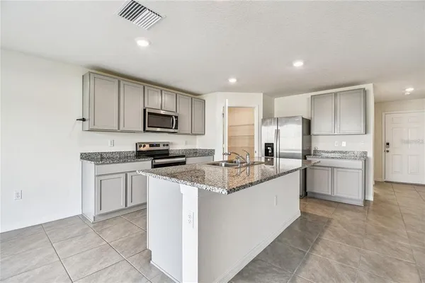 a kitchen with white cabinets sink and stainless steel appliances