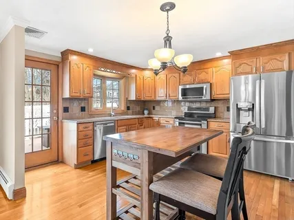 a kitchen with stainless steel appliances granite countertop a stove refrigerator and a view of living room
