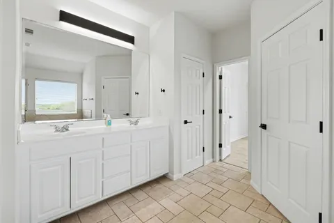 a bathroom with a double vanity sink and mirror