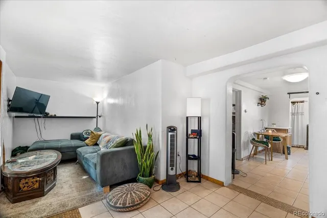 a living room with furniture and a potted plant