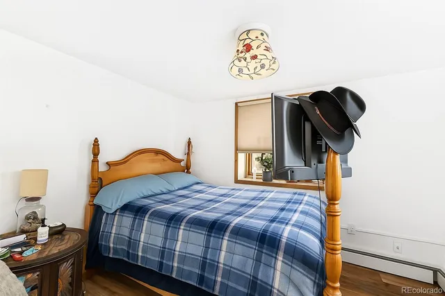 a bedroom with a bed and painting on the wall