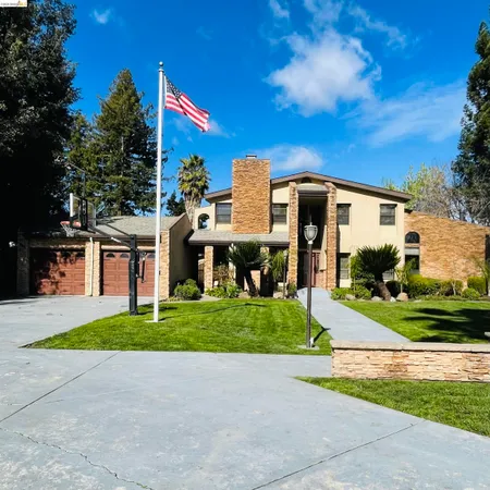 a front view of a house with a yard and trees