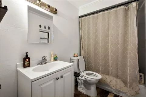 a bathroom with a sink a toilet and shower curtain