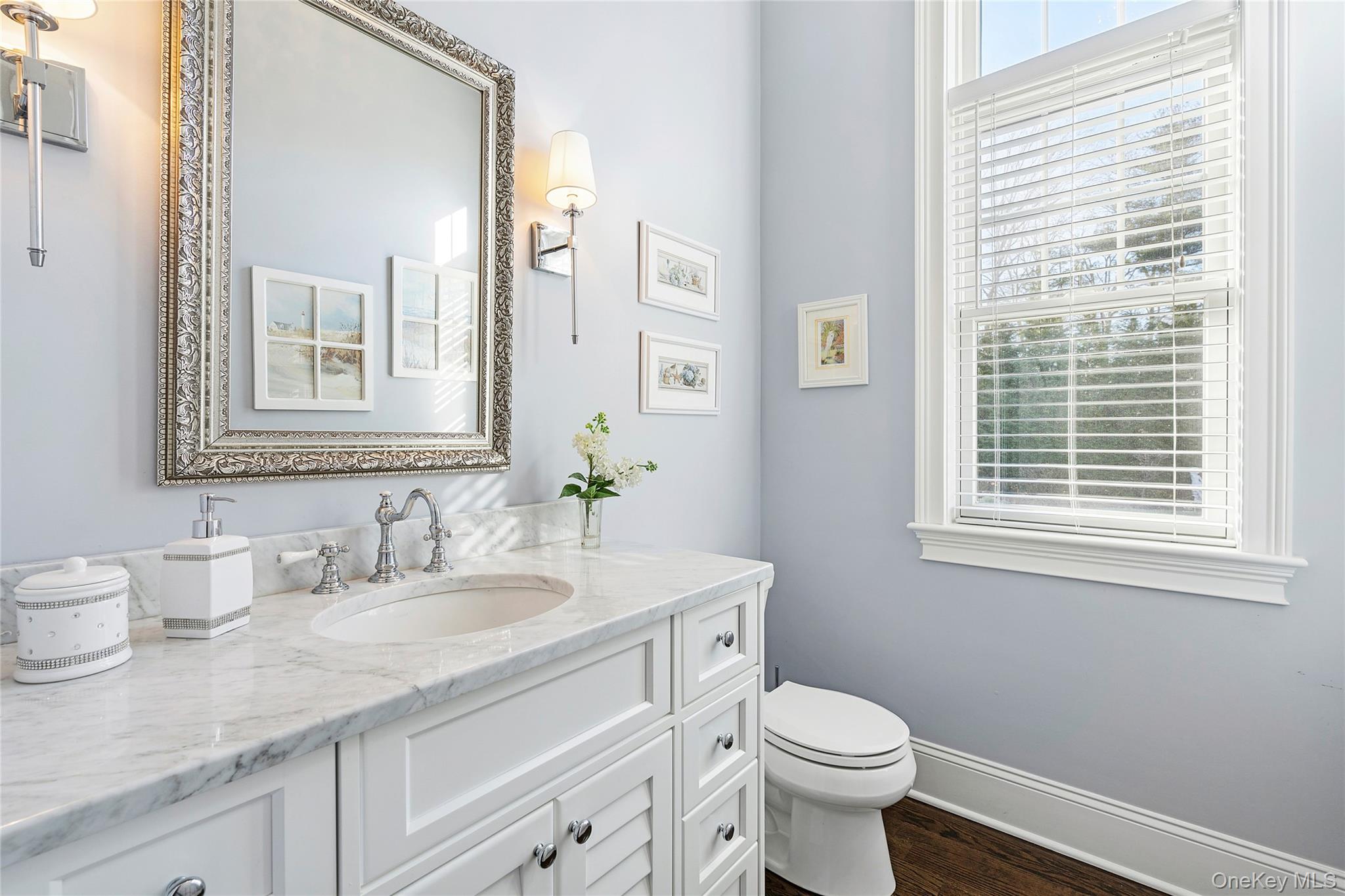 106 East Tiana Road Hampton Bays, NY 11946 - Photo 11 of 28 a bathroom with a granite countertop toilet a sink a mirror and a window