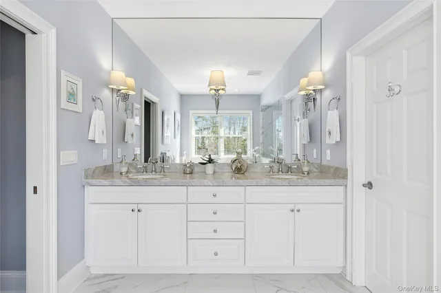 a bathroom with a granite countertop sink a mirror and a shower