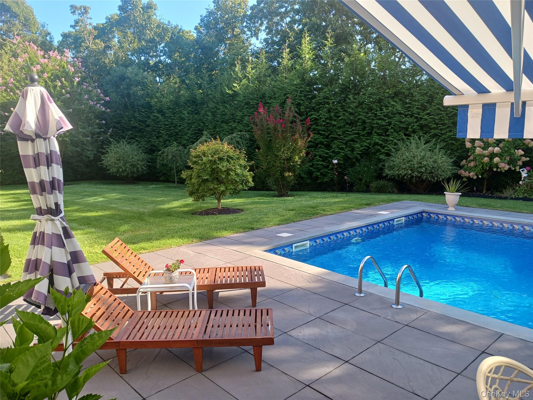 106 East Tiana Road Hampton Bays, NY 11946 - Photo 24 of 28 a view of a swimming pool with a patio and a garden