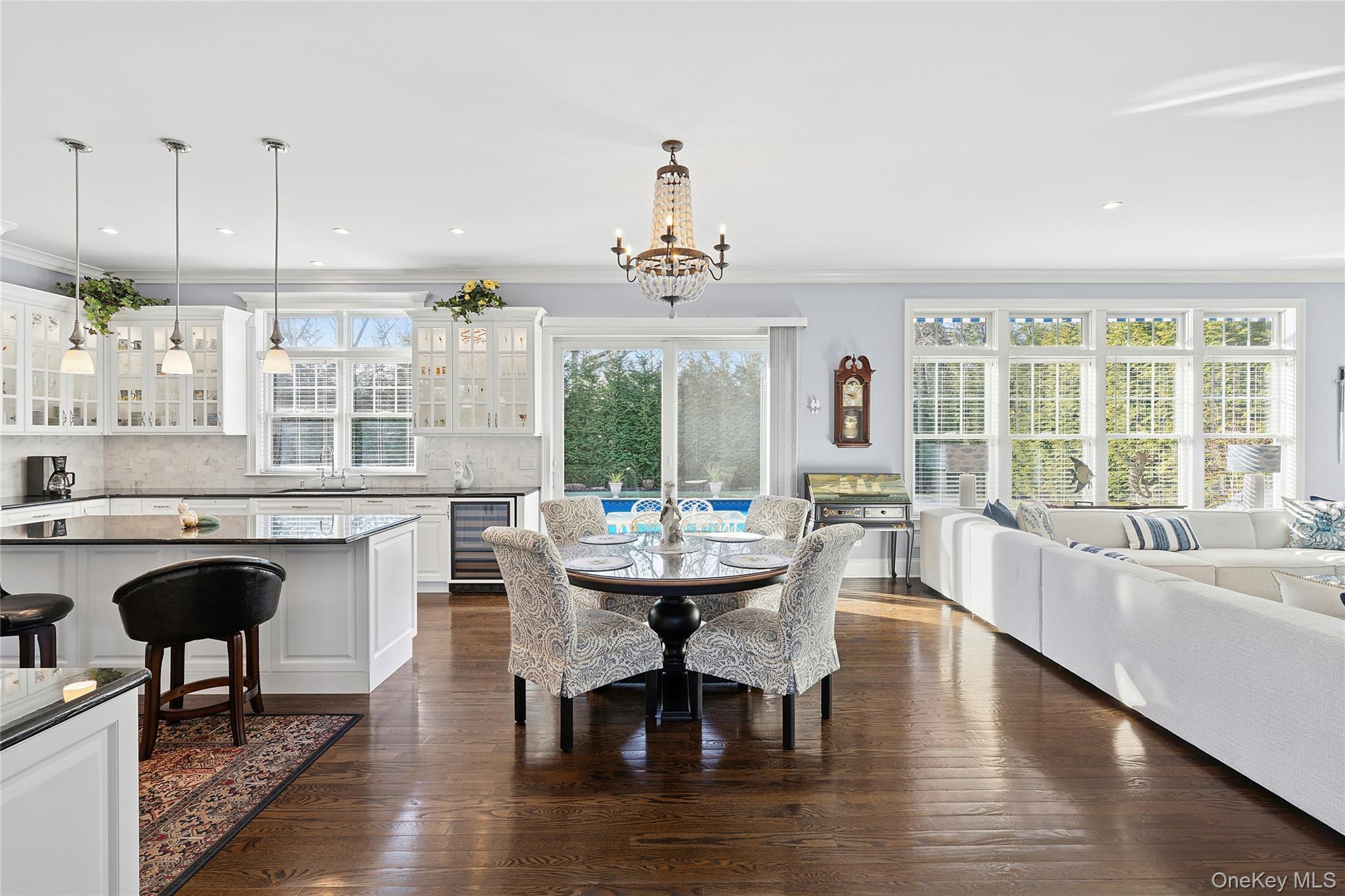 106 East Tiana Road Hampton Bays, NY 11946 - Photo 3 of 28 a dining room with wooden floor a chandelier a wooden table and chairs