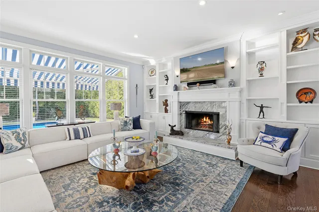a living room with furniture a large window and a fireplace