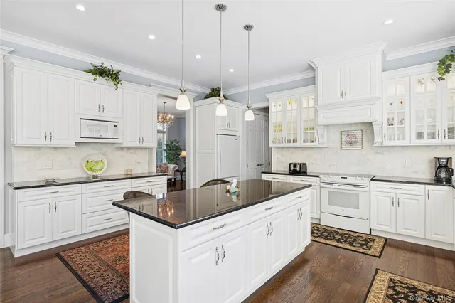 a kitchen with white cabinets and white appliances