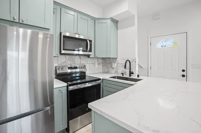 a kitchen with stainless steel appliances a refrigerator stove and microwave