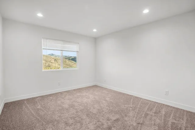 an empty room with wooden floor and window