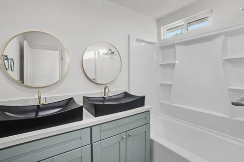 a bathroom with a double vanity sink and a mirror