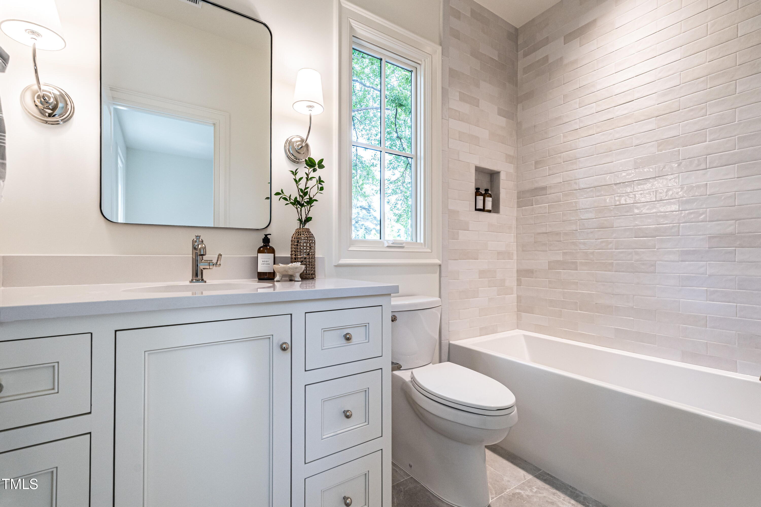 1222 Duplin Road Raleigh, NC 27607 - Photo 22 of 39 a bathroom with a toilet a sink a tub and mirror