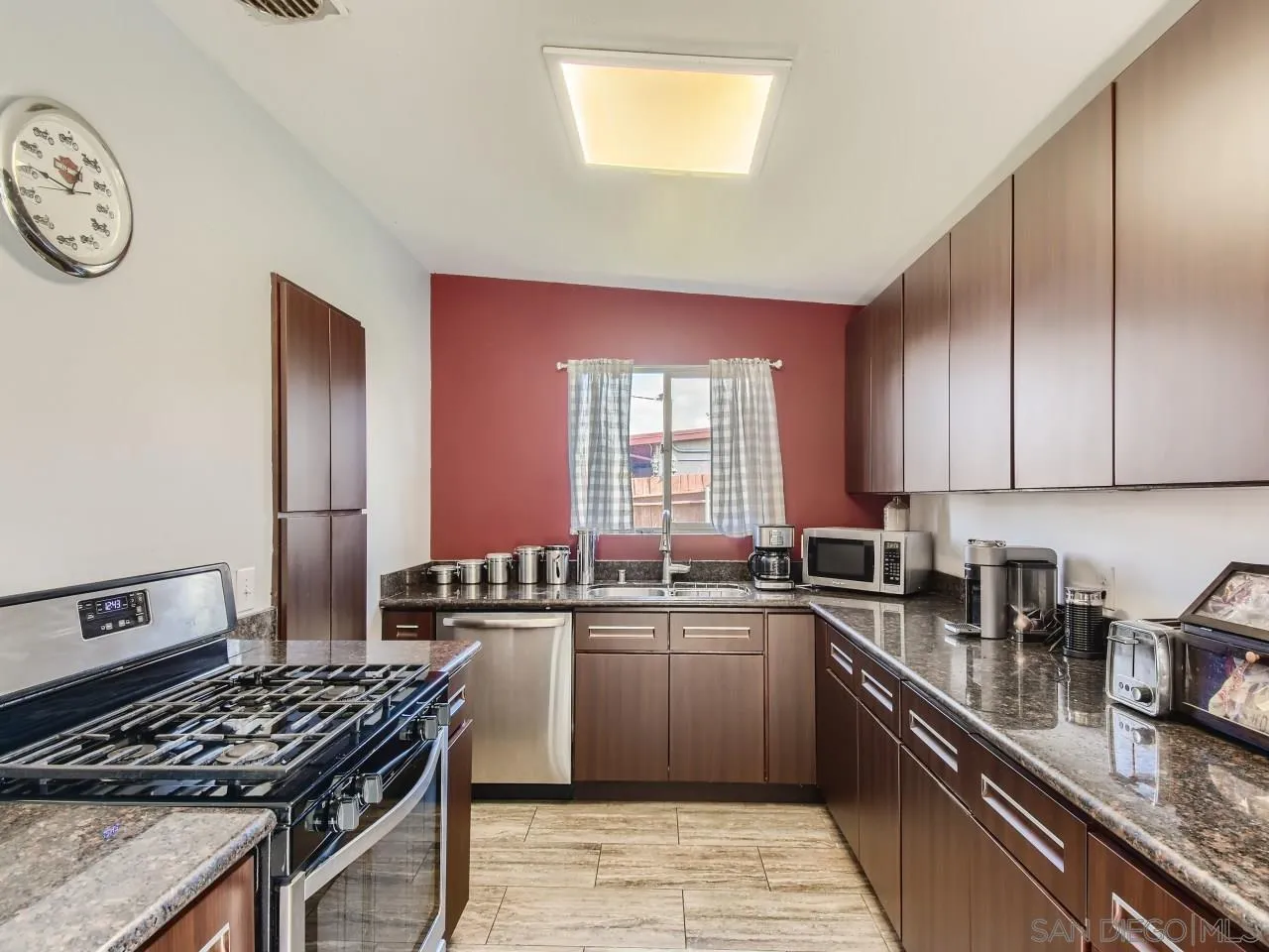 1401 9th Street Imperial Beach, CA 91932 - Photo 8 of 26 a kitchen with stainless steel appliances granite countertop a stove a sink dishwasher and cabinets with wooden floor
